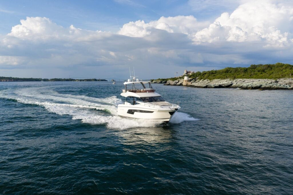 Motor yacht At Eaze passing a lighthouse off Newport, Rhode Island