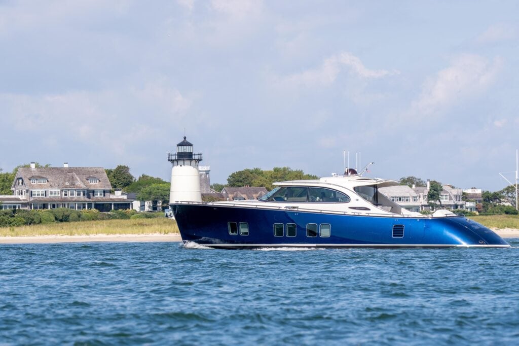 Blue-hulled motor yacht passing a lighthouse off Martha's Vineyard