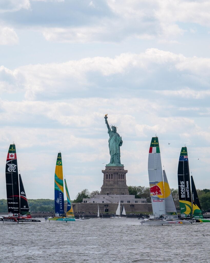 SailGP fleet racing past the Statue of Liberty, New York