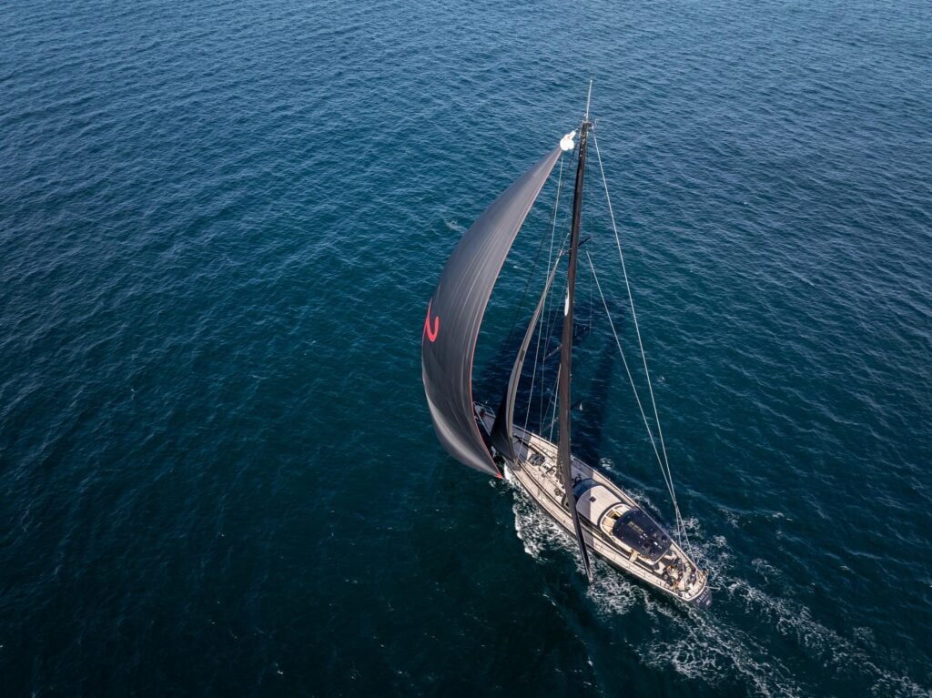 Dark-hulled sloop heeling under sail off Newport, Rhode Island
