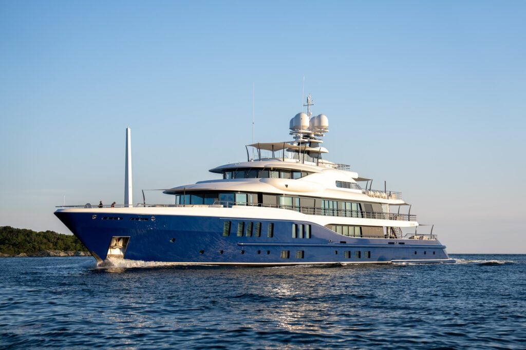 Navy-hulled classic motor yacht at anchor off the Rhode Island shore