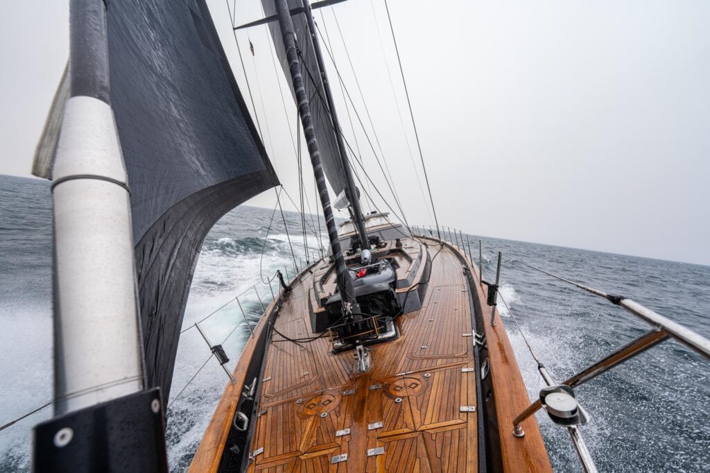 Furled headsail and varnished deck detail aboard a sailing yacht